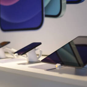 Mehrere Tablets werden in einem Elektronikgeschäft auf einem weißen Verkaufstisch ausgestellt.